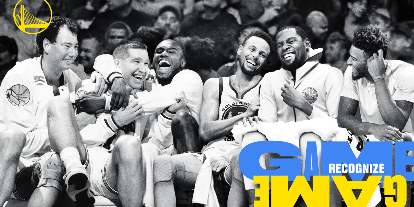 Black and white photo of a group of Golden State Warriors basketball players sitting on the sidelines. They are laughing and poking good fun at each other. The team’s logo is in the top left corner in golden yellow and on the bottom right corner is text that reads “game recognize game” but the second “game” is upside down.