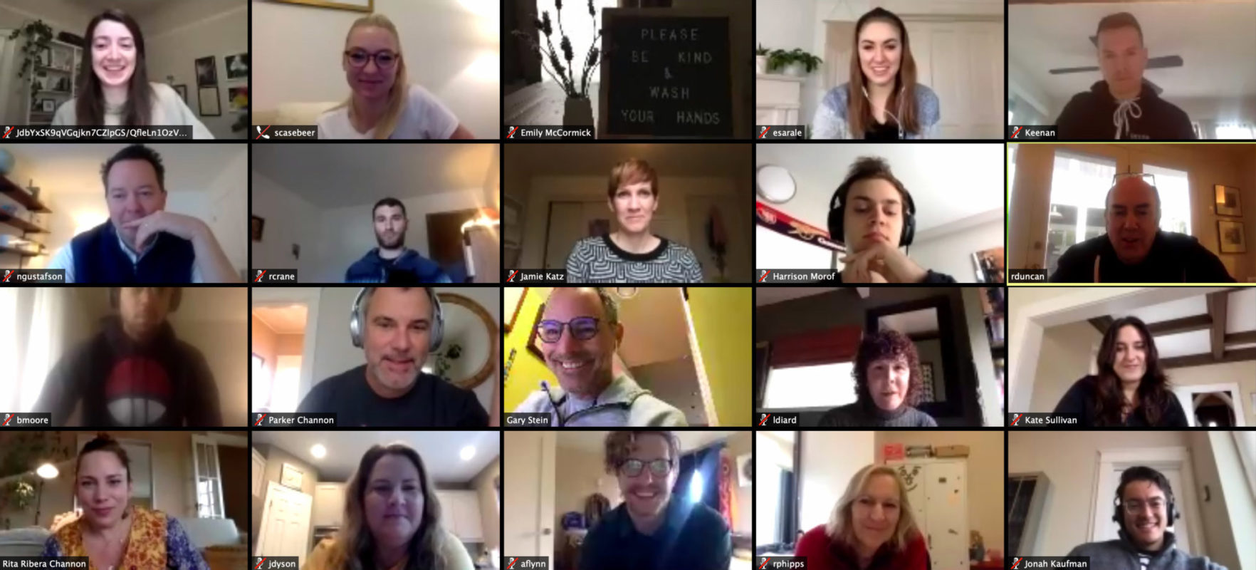Grid image of 20 US employees on video conference call together. They are diverse in their age and their genders. They all appear smiling and some chatting like they are familiar with each other and enjoy working together.