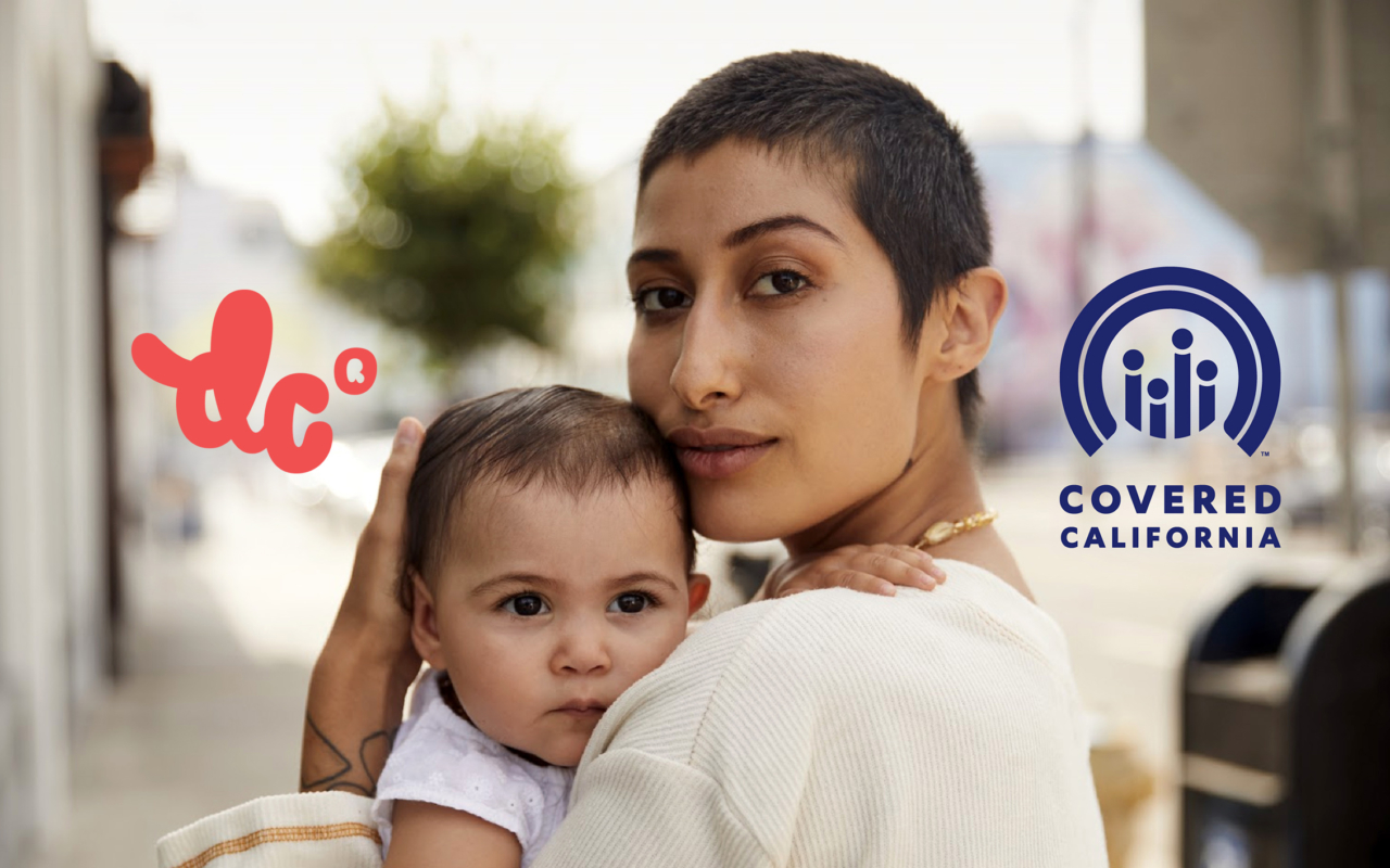 Female identified person with short-cropped brown hair, holding a baby to her chest. DC and Covered California Logos overlay the image on left and right, respectively.