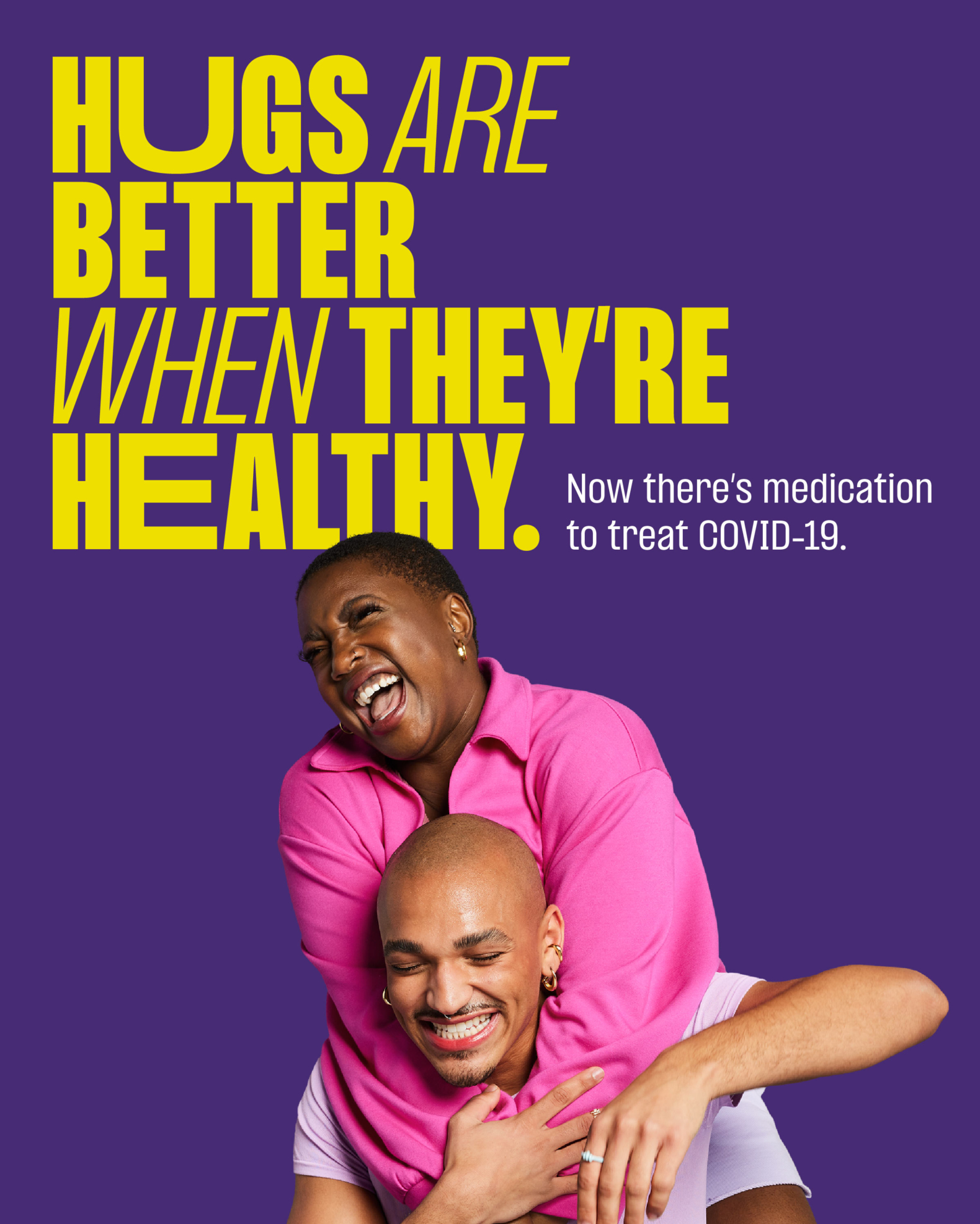 Vertical ad with dark purple background with bold yellow type on top left reading, “Hugs are better when they’re healthy.” Followed by small white type reading, “Now there’s medication to treat COVID-19.” A woman wearing a bright pink jumper has jumped on the shoulders of a man with a lavender t-shirt, both are smiling in a celebratory manner.