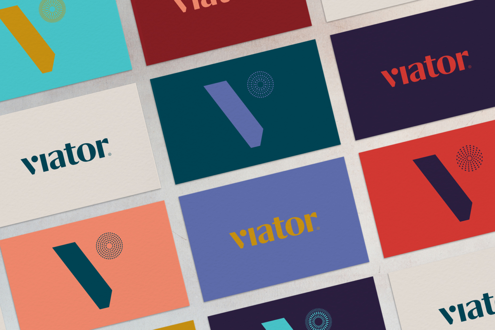 Overhead shot of a variety of Viator business cards. The shot demonstrates the range of the new Viator color palette and the brand’s new logo. Colors of the palette include gray, teal, periwinkle, salmon, eggplant, turquoise, scarlet and coral.